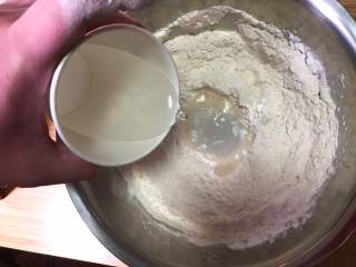 7、自制披萨,分次加入水慢慢搅拌，开始揉面