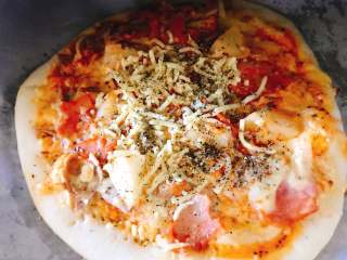 16、自制披萨,打开烤箱在批萨上加入部分马苏里拉、黑胡椒、意大利香料