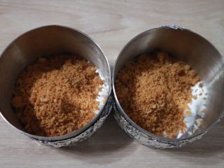 4、覆盆子生乳酪蛋糕,平均的放入两个慕斯模具中，模具底部我包了锡纸