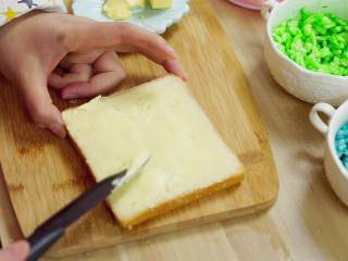 5、彩虹吐司制作图文详细教程, 自己动手做爆款高颜值网红小吃,然后在吐司一面抹上黄油（这里需要抹两片吐司哟）两片吐司都是单面抹上黄油