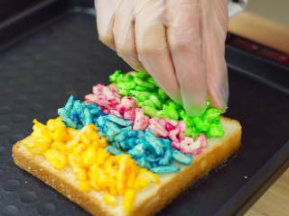 7、彩虹吐司制作图文详细教程, 自己动手做爆款高颜值网红小吃,另一面则加入我们调好色的芝士就行了，加入芝士的时候记得一种颜色一条这样加（千万不要混着加哟），混色出来的就不是彩虹了，那就是迷彩啦，哈哈