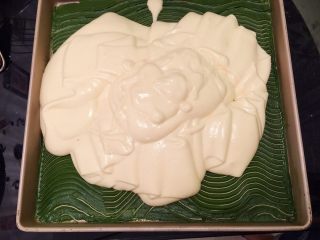 11、波浪抹茶蛋糕卷,蛋清和蛋黄糊分2次上下翻拌均匀，倒入一抹茶糊的金盘内，左右晃动均匀后轻震去气泡