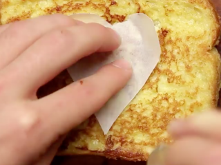 12、厨房老湿，快速做草莓法式吐司,把爱心纸放在面包片上面，抠出面包爱心