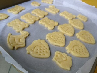 8、童趣动物饼干,把边角料移除后团成面团,再次重复擀开印模操作,直至整个面团都印成可爱的形状在油纸上