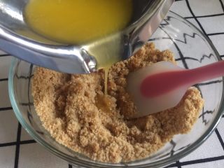 3、芒果慕斯,黄油隔水融化成液体状态，倒入饼干末中，用刮刀搅拌均匀