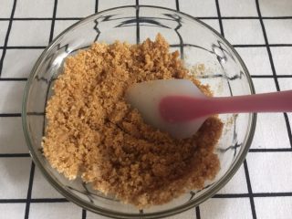 4、芒果慕斯,直到饼干末颜色都变得一致，这时候就已经拌匀了。颜色浅的地方就是没有吸收到黄油液。