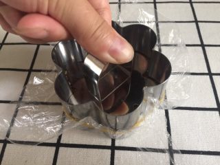 7、芒果慕斯,然后按压，一定要用力，把周围的饼干末也要压实。不然脱模和成品都会受影响，会散。如果没有专门的这种按压器具，也可用勺子按压。放入冰箱冷藏。