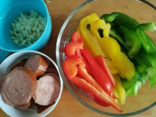 5、Pizza,蒜头切碎，红肠切片，三色椒切丝。材料准备好后，Pizza面团也差不多做好了，待程序完成，断电取出面团，静置醒发15分钟