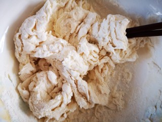 5、微波炉版美味披萨,将酵母水倒入面粉碗中，用筷子搅拌成絮状