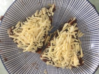 4、红豆沙芝士小软饼,把芝士撒在饼皮上，用手按压固定好，多些芝士味道会更好。