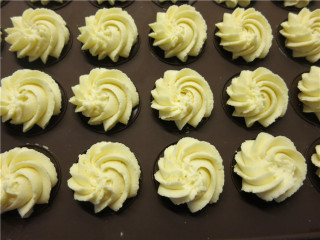 10、香酥不腻皇家曲奇, 烤盘上垫上硅胶垫，左手握裱花袋，右手出力挤，与烤盘垂直顺时针方向挤出圆形的曲奇，挤好的曲奇中间要保持一定的间距，因为烘烤时饼干会膨胀