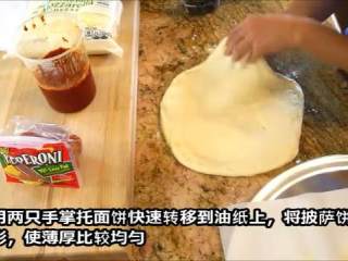 8、史上最快速简单好吃的披萨完全手工版,烤盘上放油纸，撒玉米粉。面团按成20cm左右圆饼，边缘向外抻成直径11寸左右的圆饼，在放到烤盘上