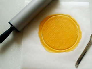 5、俄罗斯提拉米苏,在烘焙纸上依次把九个小面团擀成面皮,越薄越好,用圆形慕斯圈(我用的是大碗)把面皮切割成正圆形,边角余料不要扔掉