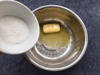 3、奶香小酥饼,黄油倒入盘中后,加入细砂糖。