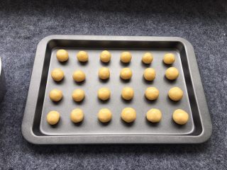 13、奶香小酥饼,将小圆球放入烤盘里(我用的是不粘烤盘,无需放油纸,可以根据自己的烤盘考虑是否需要放油纸)