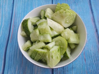 1、拉皮花生黄瓜凉菜,准备一个黄瓜拍一拍，然后切成块。