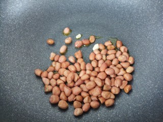 5、拉皮花生黄瓜凉菜,锅里倒油，花生放进去炒。