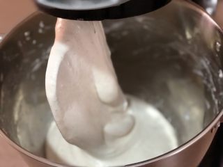 5、迷迭香佛卡夏(天然酵种),这个过程重复几次,停机时用手测试面糊的筋度,当用手指滑动面糊时明显感到有弹性了,这时加入盐7g,糖4g,酵母粉2g。再次启动厨师机3档揉面,让刚加入的材料和面糊充分融合。面糊开始出现变化,逐渐形成面团,脱离缸壁缠裹在浆形头上。面团变得闪亮光滑、极具弹性。揉面完成。