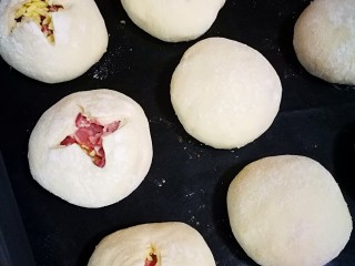 5、培根奶酪岩浆面包,进行二次发酵。大约半小时，发酵原来的两倍大之后，用剪刀先剪一个较大的口子，再在切口垂直方向剪十字。