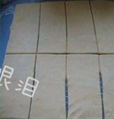 3、菠萝派,用刮板将面团裁成正方形，再分成相同大小的小长方形若干。