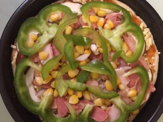 4、培根披萨,静置15分钟再次发酵后涂上披萨酱，奶酪，铺上所有配料。烤箱预热5分钟，放进烤箱210度左右，烤25分钟