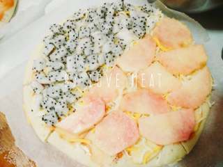 3、水果双拼披萨(九寸),撒上一层芝士 在香蕉上铺火龙果块 苹果片上铺桃片