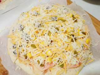 4、水果双拼披萨(九寸),撒甜玉米和青豆 在有苹果那一半撒些葡萄干 铺一层芝士 再撒一点玉米和芝士 入烤箱180°十多分钟至芝士融化呈金黄色