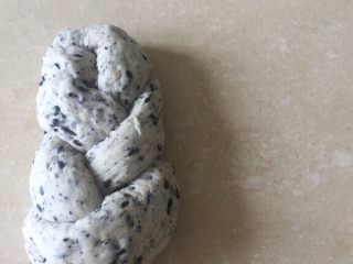 20、佛系养生黑芝麻辫子面包,第二十步：然后把左边的塞进洞口中整理好就好了