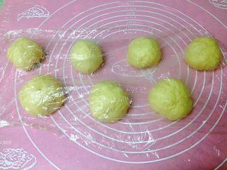 3、芝士肠仔包,一次发酵好的面团均分成6-8份，盖上保鲜膜松弛15分钟。
