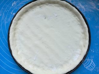 7、奥尔良鸡肉披萨,烤箱上下火200度预热10分钟。面团取出，擀成圆片，放进刷了油的披萨盘内，用手推整出圆边。