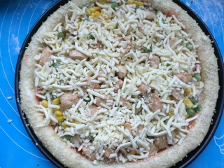 20、奥尔良鸡肉披萨,最后撒上所有的马苏里拉芝士，送入预热好的烤箱，上下火200℃烘烤18分钟即可。