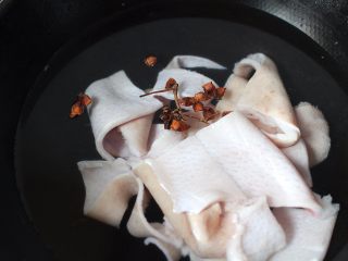 2、麻辣猪皮冻,将猪皮冷水下锅，锅内放入几个八角，家里如果有生姜的话也可以切几片生姜进去！盖上盖子，大火煮沸后，转中小火煮15分钟