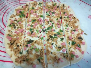 11、葱香肉松手撕包,再用刮板把面片从中间切开，切成4份。