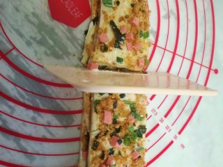 13、葱香肉松手撕包,用刮板从中间切开。