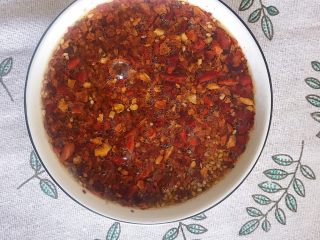 13、川香口水鸡,锅里热油倒进碗里 一边搅拌一边泼油 辣椒油就做好啦