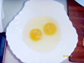 2、芝士培根鸡蛋脆饼,鸡蛋打入碗中