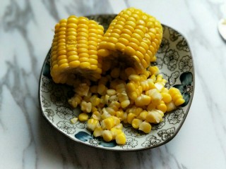 5、香甜玉米粒披萨,煮熟玉米捞出，待玉米不烫手时，将玉米粒搓下来。