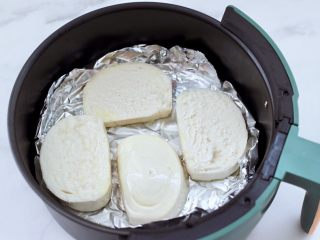 3、逆天好吃的馒头培根时蔬披萨,把切片的馒头放入炸篮中。