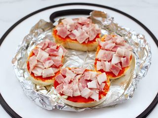 7、逆天好吃的馒头培根时蔬披萨,烤好的馒头片，先铺上一层培根。