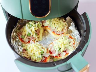 11、逆天好吃的馒头培根时蔬披萨,空气炸锅200度提前预热5分钟，把做好的馒头披萨胚放到炸篮里。