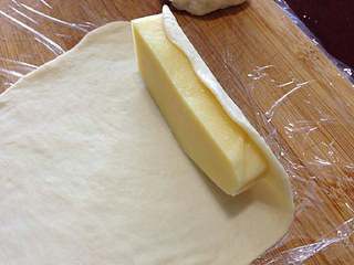 7、【芝心培根蘑菇披萨】,把芝士条放在薄面皮上。