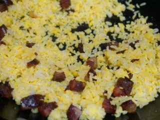 5、黄金蛋炒饭,待蛋黄完全包裹住米饭后，下入刚刚炒好的腊肠丁拌匀