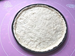 12、培根披萨,擀好的面皮放入烤盘，边缘要多出来，用叉子戳满满的小孔
