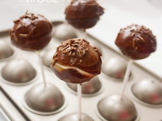 20、巧克力棒棒糖蛋糕,黑巧克力隔水溶化，把刚刚沾好白巧克力的棒棒糖蛋糕再在黑巧克力上沾一次，这样成品能看出有双色巧克力，然后在表面撒上一些黑巧克力针做装饰