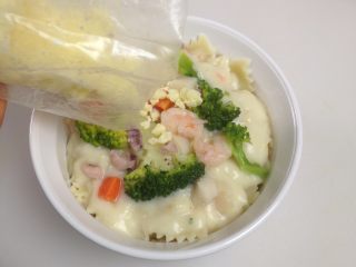 6、海鲜蔬菜酱焗意面,在表面上均匀的覆盖上芝士