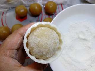 18、广式月饼~莲蓉蛋黄月饼,模具放入花片，放入包好并且沾过面粉的月饼，也可以在月饼模具中撒一些粉防粘，粉在模具中晃一晃，再把多余粉倒掉。