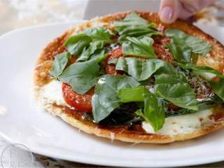 3、简易版烤饼迷你披萨,烤箱预热到200度. 把烤饼(5)放在铺好锡纸的烤盘上，淋上橄榄油(适量).