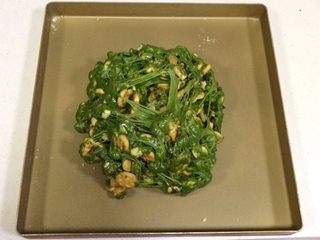 12、抹茶雪花酥,把雪花酥团倒入不粘烤盘内，用双手不停往外翻，直到饼干和坚果料都被千丝万缕的糖包裹住。