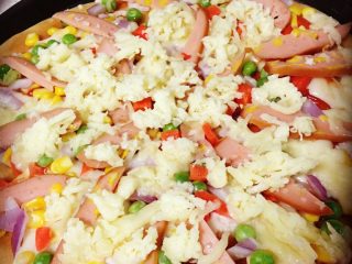 4、电饼档披萨,如图：面团用擀面杖压成面饼。（忘记拍面饼）家里木有擀面杖。。。用的保鲜膜那个压的，所以不圆，哈：）将面饼放入电饼档，先涂一层番茄酱，然后撒上青豆等材料，铺上香肠。最后放马苏里，打开电饼档，等吃咯咯：）