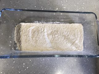 4、奶黄冰皮月饼,期间制作糕粉。将50克糯米粉倒入不粘锅翻炒,颜色发黄即可,倒入盘里放凉备用。